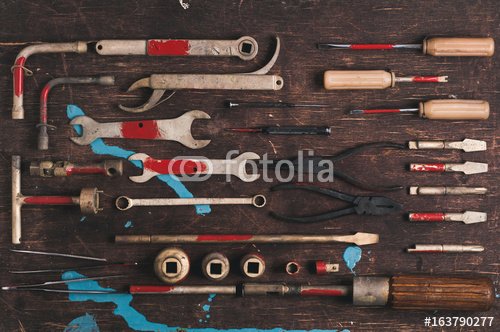 A set of old tools for the professional mechanic over old wooden background