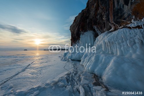 The icy splashes on the rock at dawn light, winter lake Baikal, Kurminskiy bay