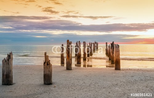 Deserted beach and and the remains of the ruined pier in  the water  . The sea is minimalist. Coast the Gulf of Mexico. Florida. USA
