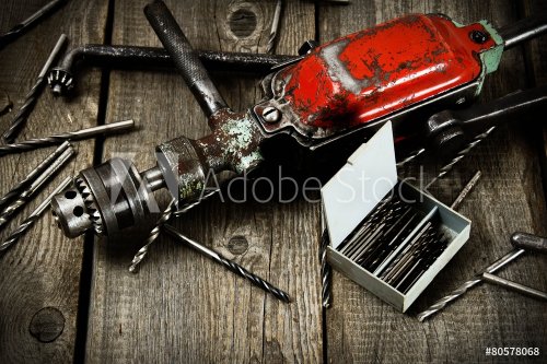 drill with drills on a wooden background. - 901144062