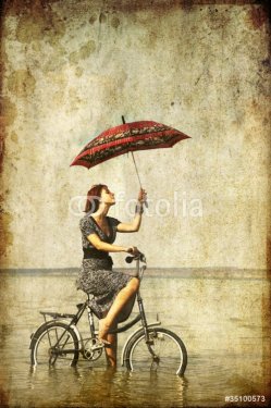 Girl with umbrella on bike. Photo in old image style. - 900281670