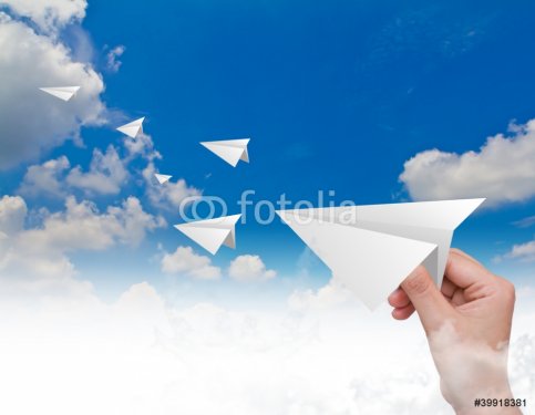 Hand throwing a paper plane in the sky - 900398886