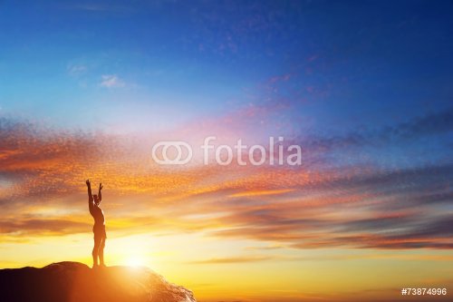 Happy man with hands up on peak of the mountain at sunset - 901148951