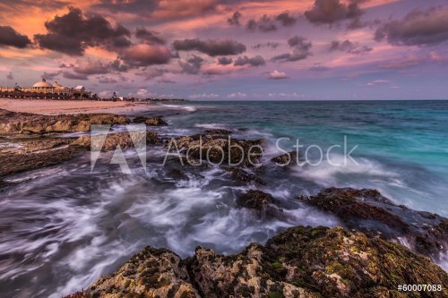 Purple sunset over a tropical rocky beach - 901141640
