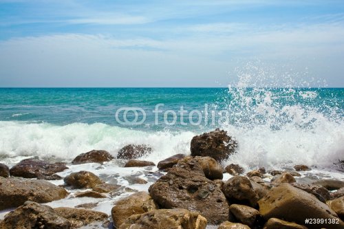 Rocks in the waves and sea foam. - 900636376