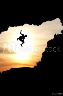 silhouette of man jumping of rock - 900454186