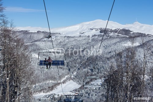 Ski lift with seats going over the mountain - 901146453