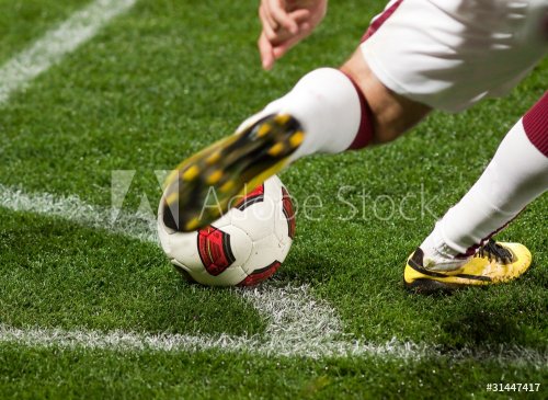 Soccer player kicking the ball from corner