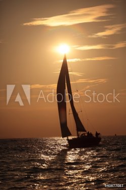 Yacht and sails against the sunset sky