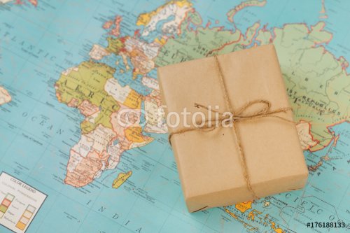 International shipping. Cardboard box on the geographical map background - 901152665