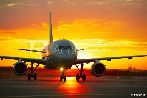 Airplane at sunset - back lit - 901155212