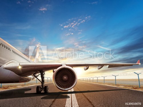 Close-up of airplane on runway in sunset light - 901155218