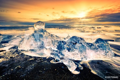 Drifting icebergs on Diamond beach, at sunset, in Jokulsarlon, Iceland