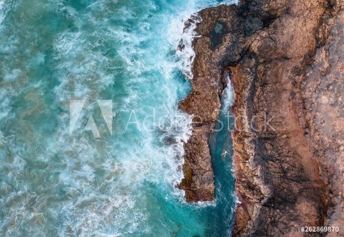 High angle view of a man relaxing in the natural swimming pool at the ocean's... - 901155503