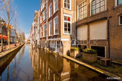 Historic buildings border a canal, along Voldersgracht street, in the old cen... - 901155480