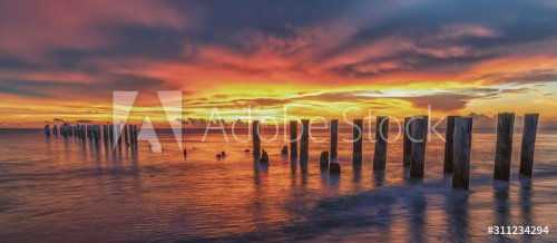 Old Pier at sunset. Scenery at the beach. Travel concept