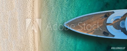 Vue aérienne d'un bateau luxueux près d'une plage d'eaux turquoises