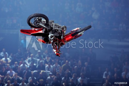 A freestyle moto cross rider performs a trick - 901145485
