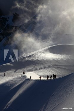 A group of alpinists on their way to the mont blanc at dawn.