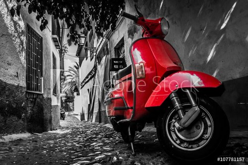 A red vespa scooter parked on a paved street - 901153030