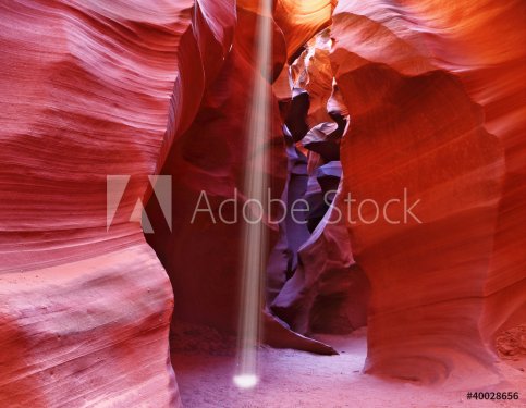 A thin ray of sunlight illuminates the canyon