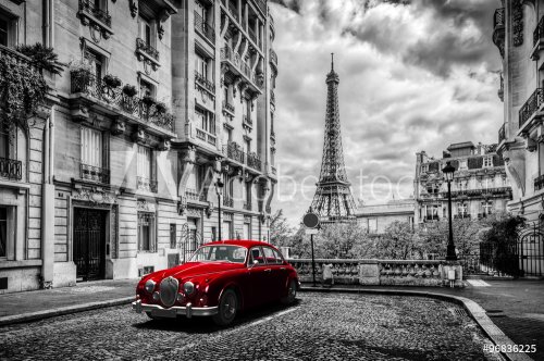 Artistic Paris, France. Eiffel Tower seen from the street with red retro limousine car.