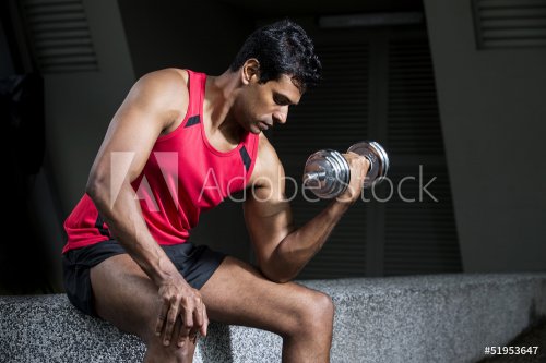 Athletic Indian man exercising with dumbbells