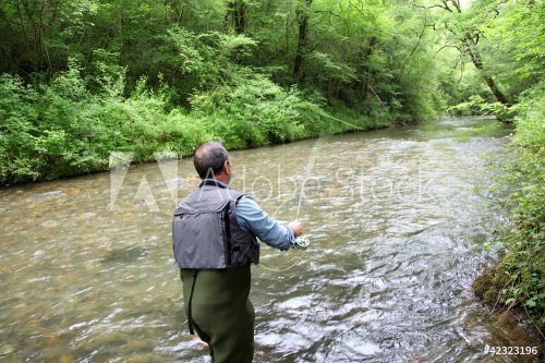 Back view of fisherman in river fly fishing