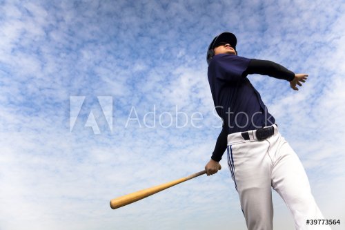 baseball player taking a swing with cloud background - 900390758