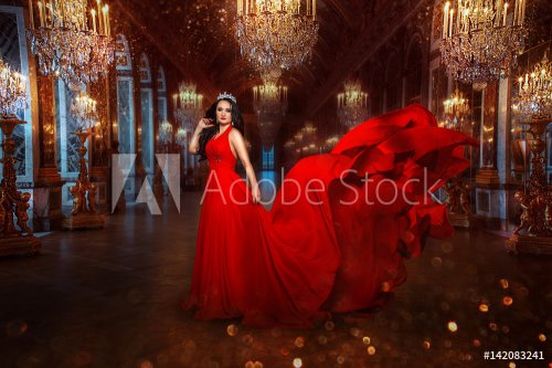 Beautiful charming girl in a luxurious red dress on the background of the gol... - 901151407