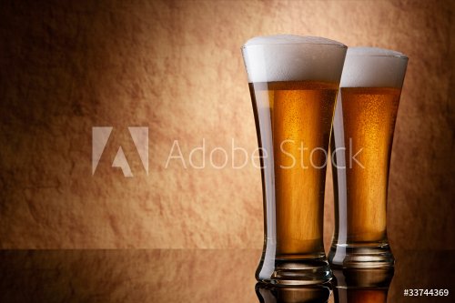 Beer into glass on a old stone - 900020781