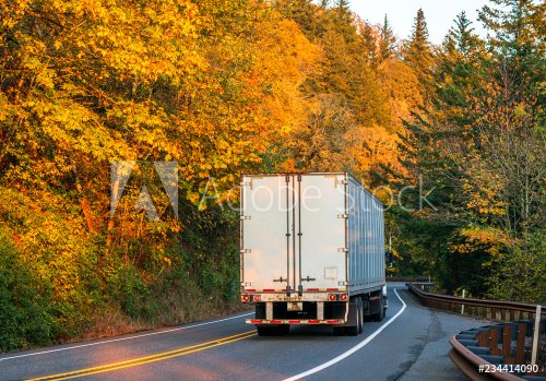 Big rig semi truck transporting semi trailer with cargo on winding road with ... - 901152650