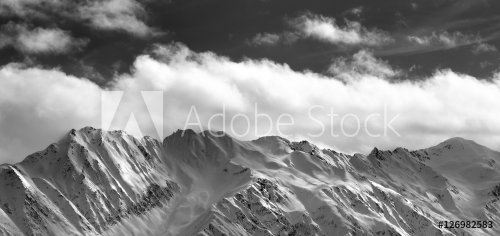 Black and white panoramic view on snow winter mountains and sunl