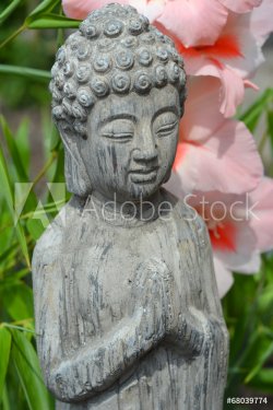 Boeddha in  bamboe tuin met bloemen