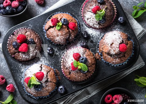 Chocolate orange muffins or cupcakes with berries.