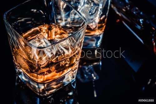 close-up of top of view of glass of whiskey near bottle on black table with reflection, old style