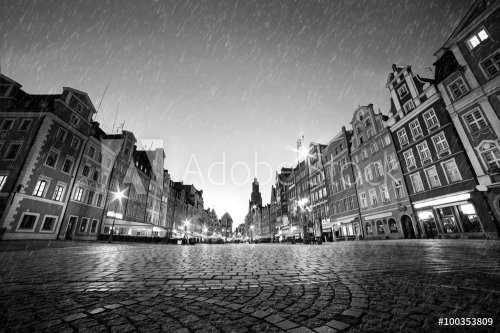 Cobblestone historic old town in rain at night. Wroclaw, Poland. Black and white