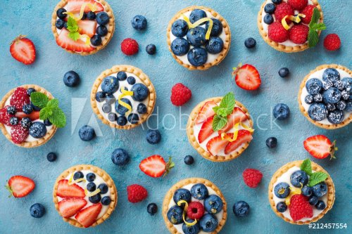 Colorful berry tartlets or cake for kitchen pattern. Pastry dessert from above.