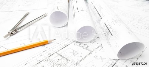 Construction blueprints rolled on the worktable - 901152751