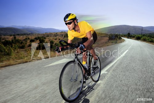 Cyclist riding a bike on an open road - 900058505