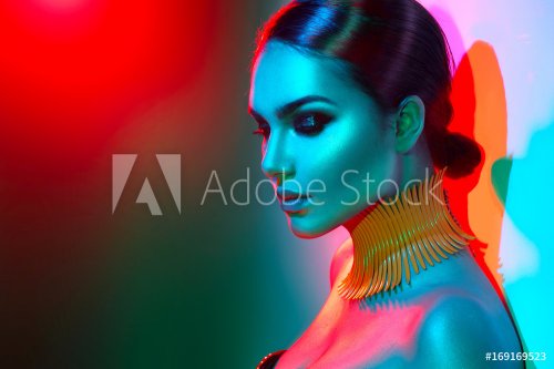 Fashion model woman in colorful bright lights posing. Portrait of beautiful s... - 901149768