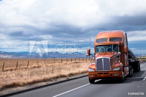 Flat bed semi truck transporting cargo under cover on California road - 901154281