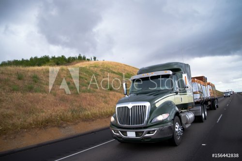 Flat bed semi truck transporting lumber cargo on California road - 901154282