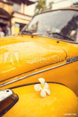 Flower Power - flower on a yellow vintage hippie car. Hippy retro style bug or beetle restored car.