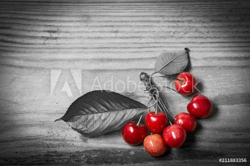 Fresh red cherries on a wooden table - selective color (black and white)