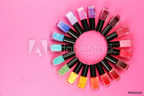Group of bright nail polishes, on pink background - 900899618