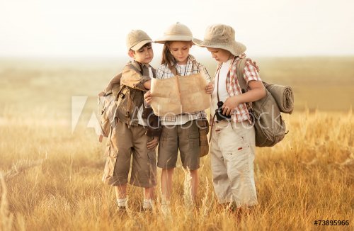 Group of kids travelers read a map at sunset - 901144115