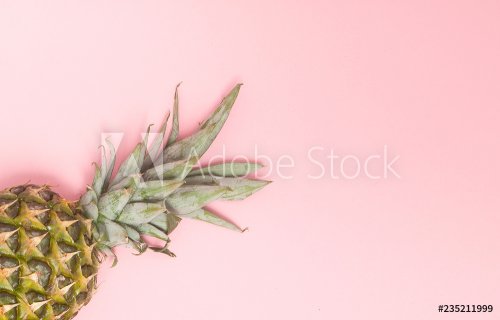Half cut juicy pineapple on a pastel pink background. Minimal summer concept