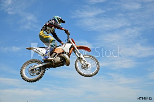 High flight by motorcycle racer motocross against the blue sky