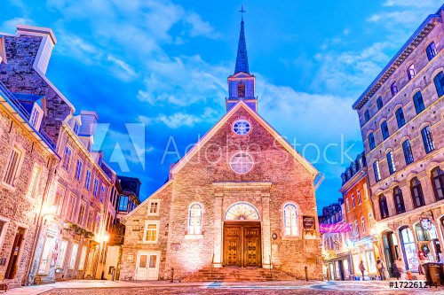 Lower old town street in Quebec City, Canada on la place Royale at dusk, night or twilight with Notre-dame-des-victories church and people with evening lights